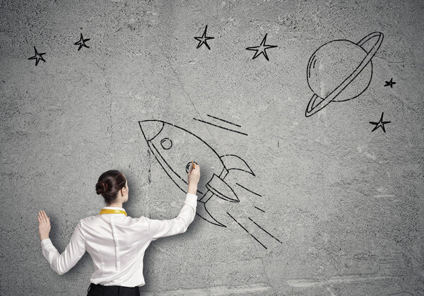 Businesswoman drawing rocket