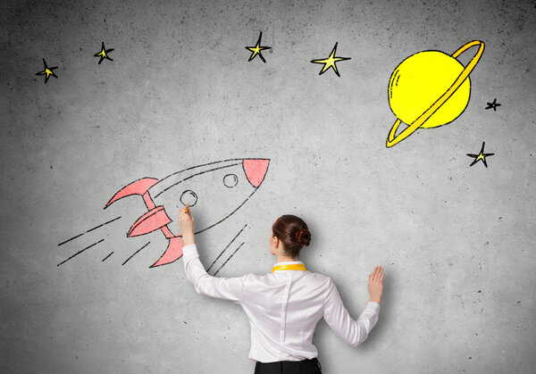 Businesswoman drawing rocket