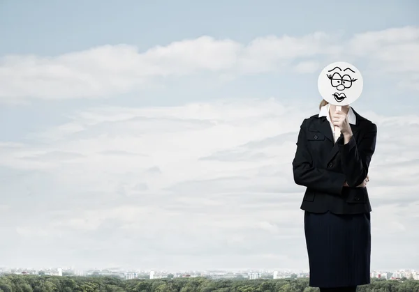 Mujer de negocios escondiendo la cara detrás de la máscara — Foto de Stock