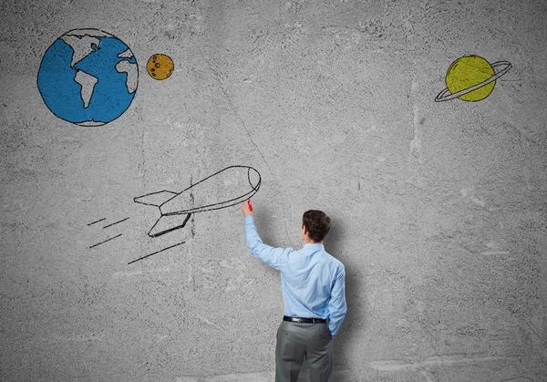 Бизнесмен рисует ракету на стене — стоковое фото