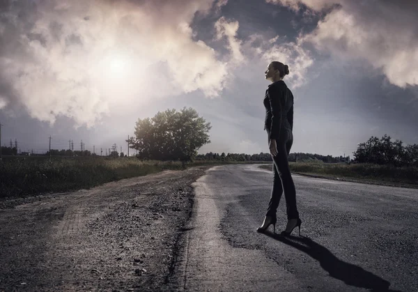 Young businesswoman standing on road — Stock Photo, Image