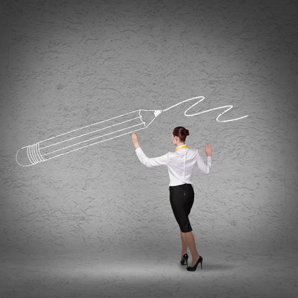 Businesswoman drawing sketches on wall — Stock Photo, Image