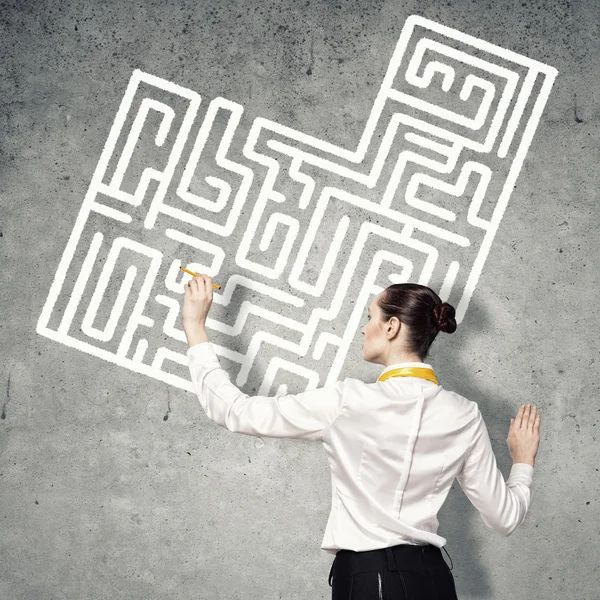 Geschäftsfrau zeichnet Labyrinth an Wand — Stockfoto