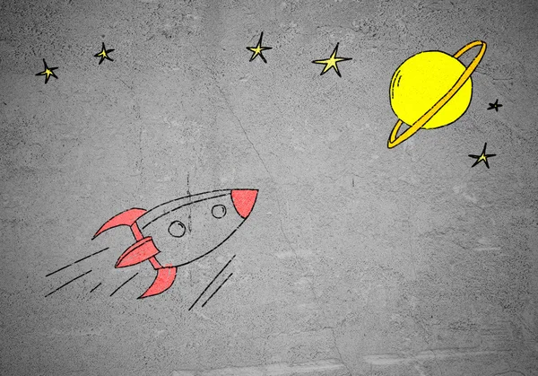 Flying drawn rocket on cement wall — Stock Photo, Image