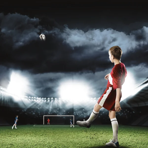 Menino jogador de futebol chutando bola — Fotografia de Stock