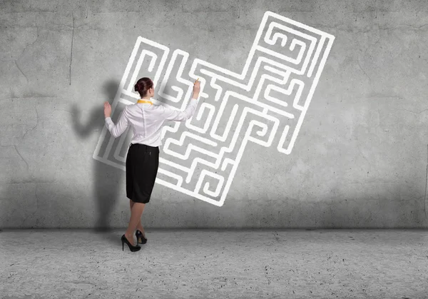 Businesswoman drawing labyrinth on wall — Stock Photo, Image