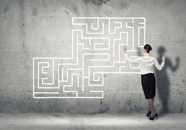 Businesswoman drawing labyrinth on wall — Stock Photo, Image