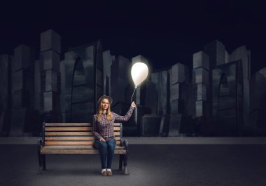 Genç bir kadın tutarak balon