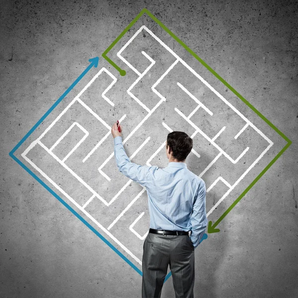 Businessman drawing labyrinth on wall — Stock Photo, Image