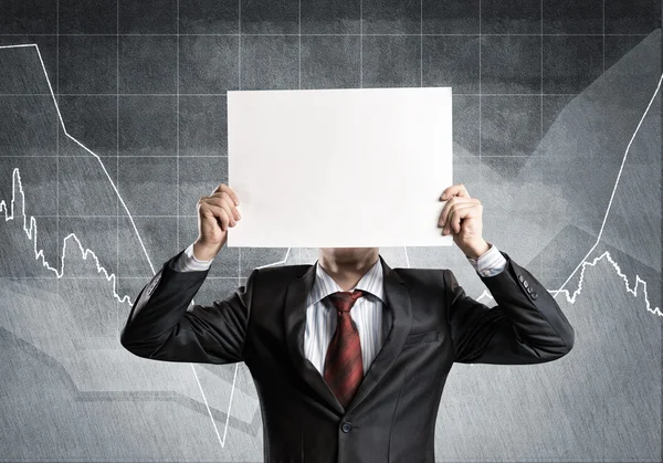 Businessman hiding his face behind paper — Stock Photo, Image