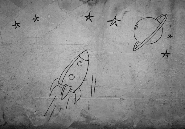 Flying drawn rocket on cement wall — Stock Photo, Image