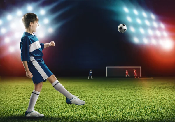 Menino jogador de futebol chutando bola — Fotografia de Stock