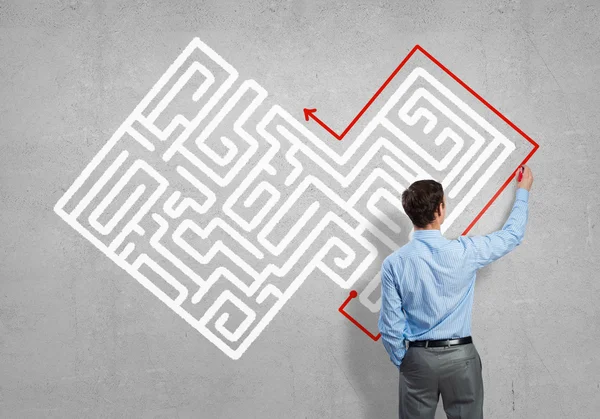 Businessman drawing labyrinth on wall — Stock Photo, Image