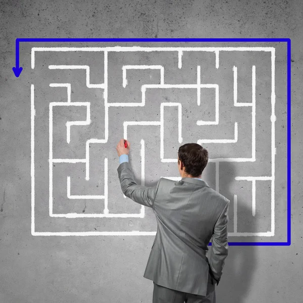 Businessman drawing labyrinth on wall — Stock Photo, Image