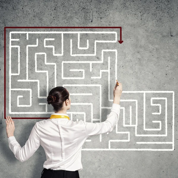 Businesswoman drawing labyrinth on wall — Stock Photo, Image