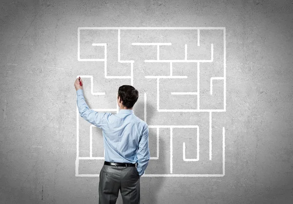 Businessman drawing labyrinth on wall — Stock Photo, Image