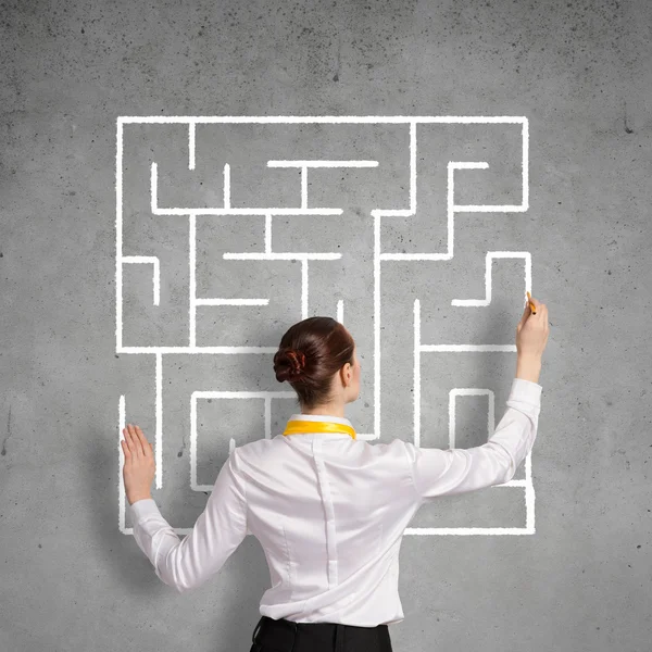 Businesswoman drawing labyrinth on wall — Stock Photo, Image