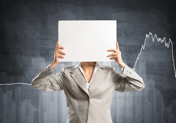 Businesswoman hiding her face behind paper — Stock Photo, Image