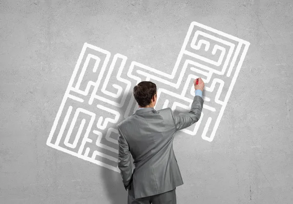Businessman drawing labyrinth on wall — Stock Photo, Image