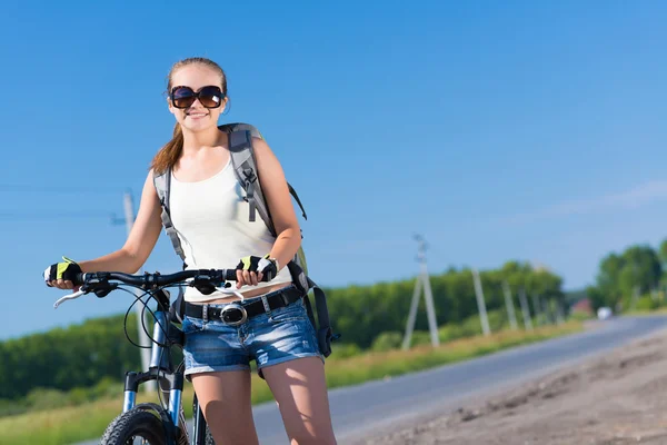 Frau mit Rucksack auf Fahrrad unterwegs — Stockfoto