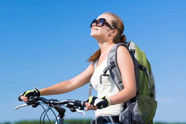 Frau mit Rucksack auf Fahrrad unterwegs — Stockfoto