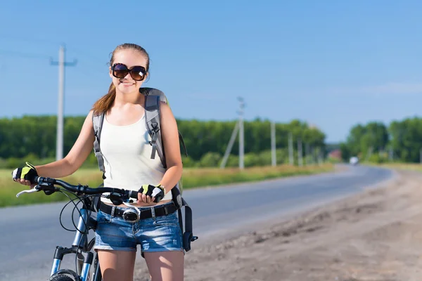 Frau mit Rucksack auf Fahrrad unterwegs — Stockfoto