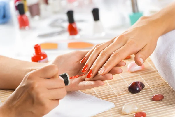 Woman in salon receiving manicure