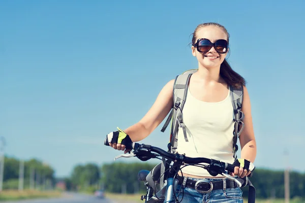 Frau mit Rucksack auf Fahrrad unterwegs — Stockfoto