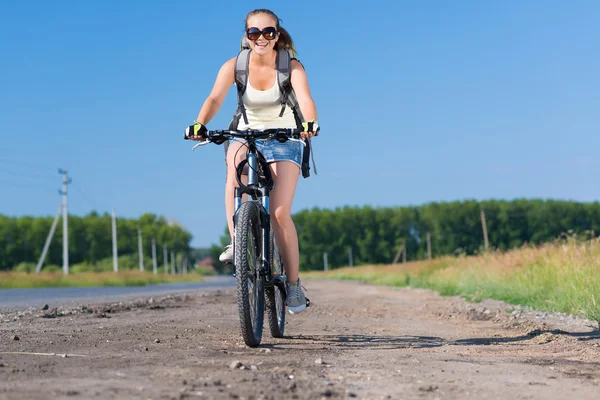 Frau mit Rucksack auf Fahrrad unterwegs — Stockfoto