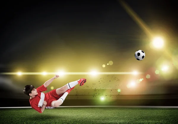 Mladej kluk kope fotbalový míč — Stock fotografie