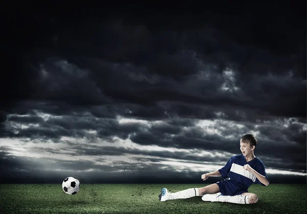 Rapaz chutando bola de futebol — Fotografia de Stock