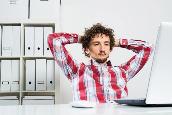 Jovem homem relaxado no escritório — Fotografia de Stock