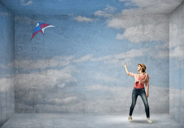 Девушка играет с летающим воздушным змеем — стоковое фото