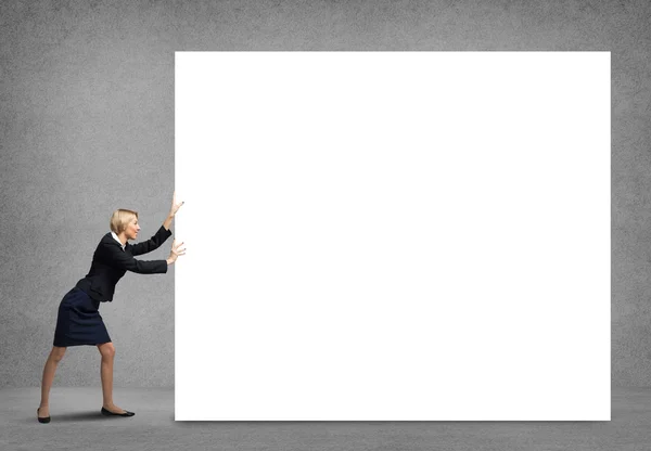 Businesswoman pushing white blank banner — Stock Photo, Image