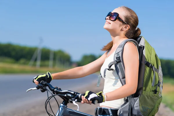 Frau mit Rucksack auf Fahrrad unterwegs — Stockfoto