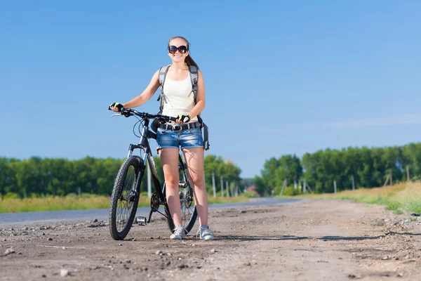 Frau mit Rucksack zu Fuß mit Fahrrad — Stockfoto