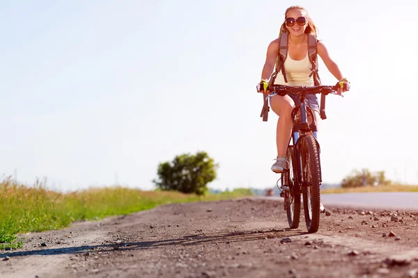 Frau mit Rucksack auf Fahrrad unterwegs — Stockfoto