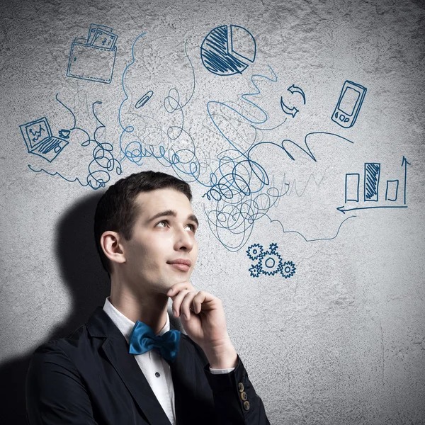 Young man looking thoughtfully at sketches — Stock Photo, Image