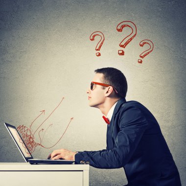 Dizüstü bilgisayarda çalışan genç adam.