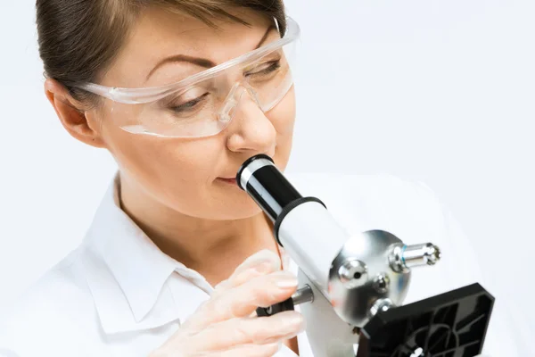 Cientista feminina olhando para o microscópio — Fotografia de Stock