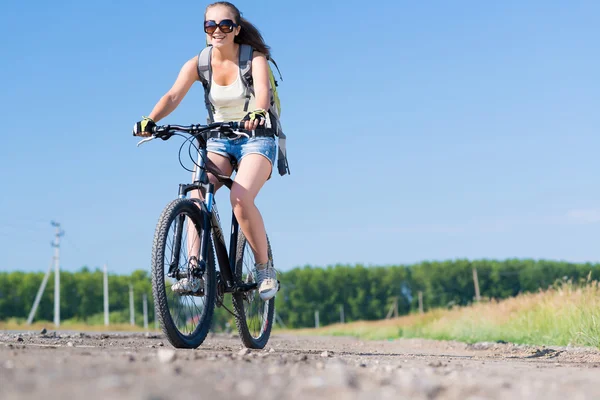 Frau mit Rucksack auf Fahrrad unterwegs — Stockfoto