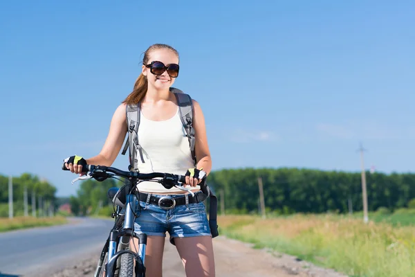 Frau mit Rucksack auf Fahrrad unterwegs — Stockfoto