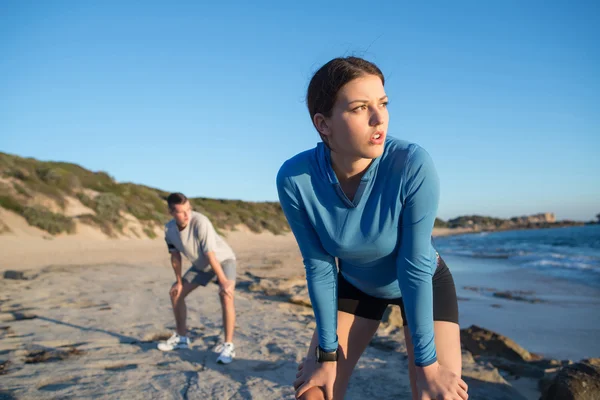 Pareja de corredores en la playa — Foto de Stock