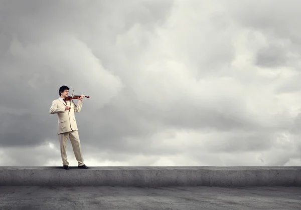 Empresário no telhado tocando violino — Fotografia de Stock