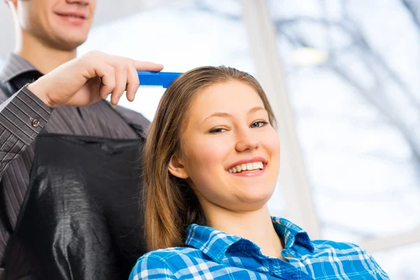 Парикмахер кладет женские волосы — стоковое фото