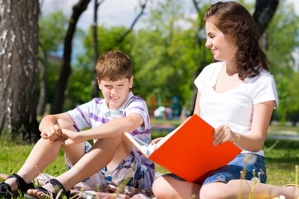 Jongen en vrouw lezing boek — Stockfoto