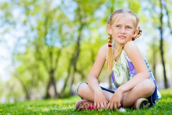 Mädchen sitzt im Park — Stockfoto