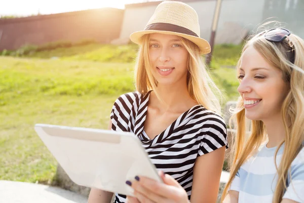 Amigos do sexo feminino usando tablet — Fotografia de Stock