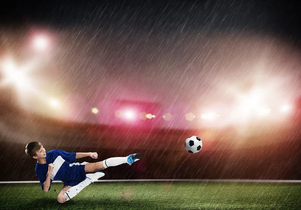 Rapaz chutando bola de futebol — Fotografia de Stock