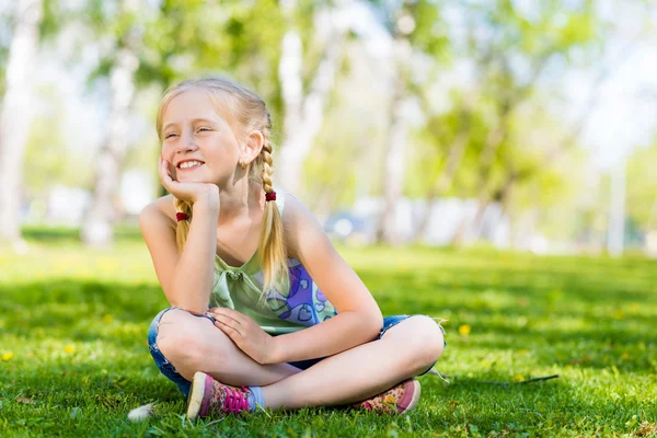 Meisje zittend in het gras — Stockfoto